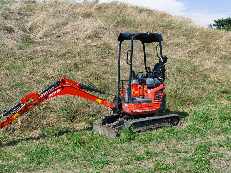 Compact excavator working a slope